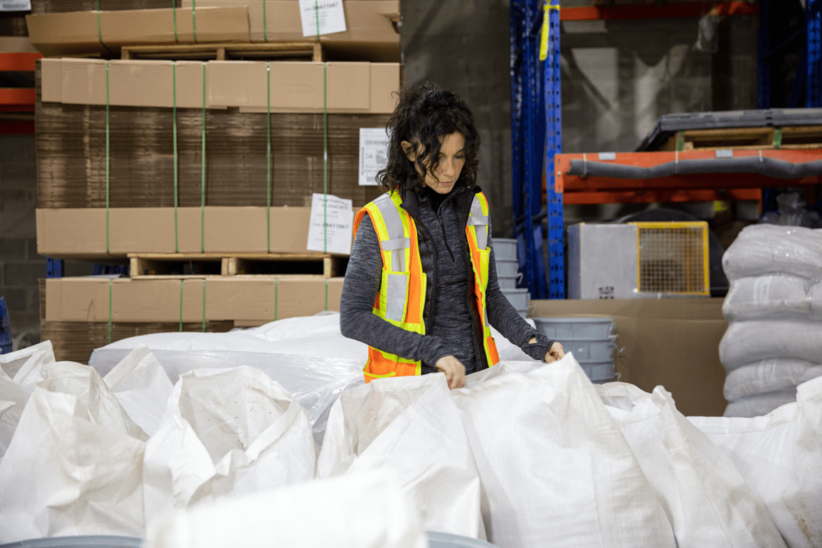 Une employé regarde des sacs de produits