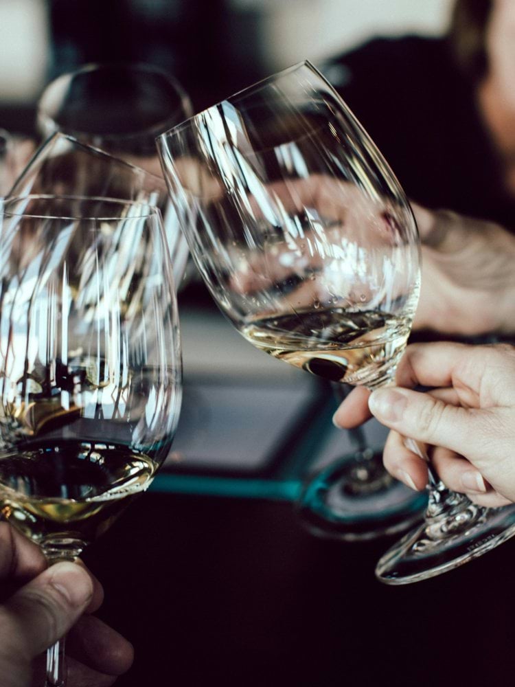 group of people holding footed glasses