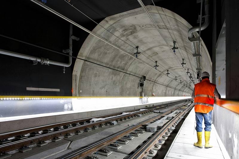 man standing beside train rail