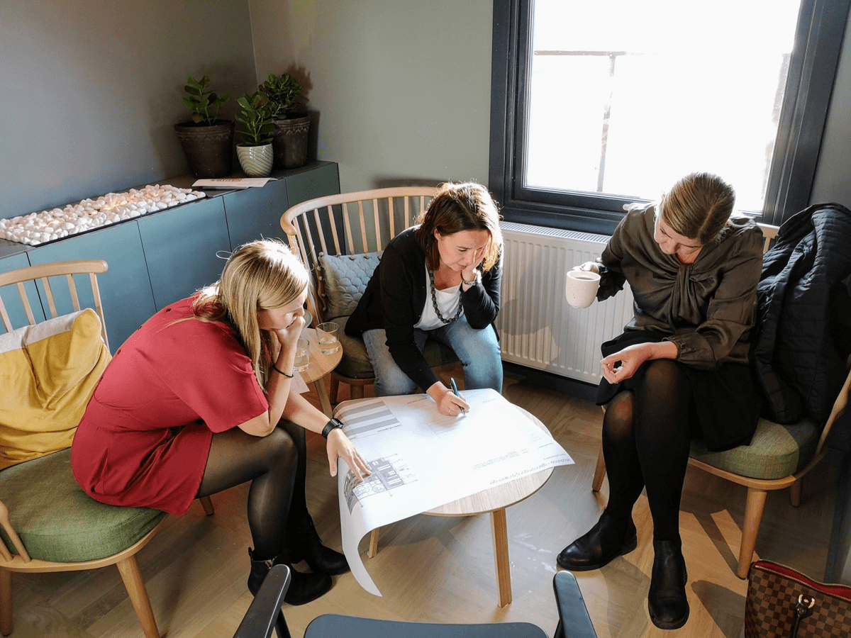 Tre kollegaer i Huseierne sitter sammen og studerer en plantegning