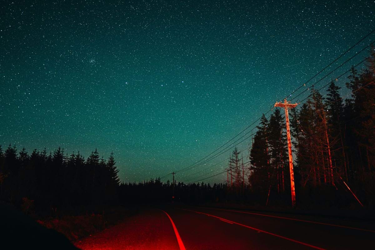 Nighttime road with stars shining above.