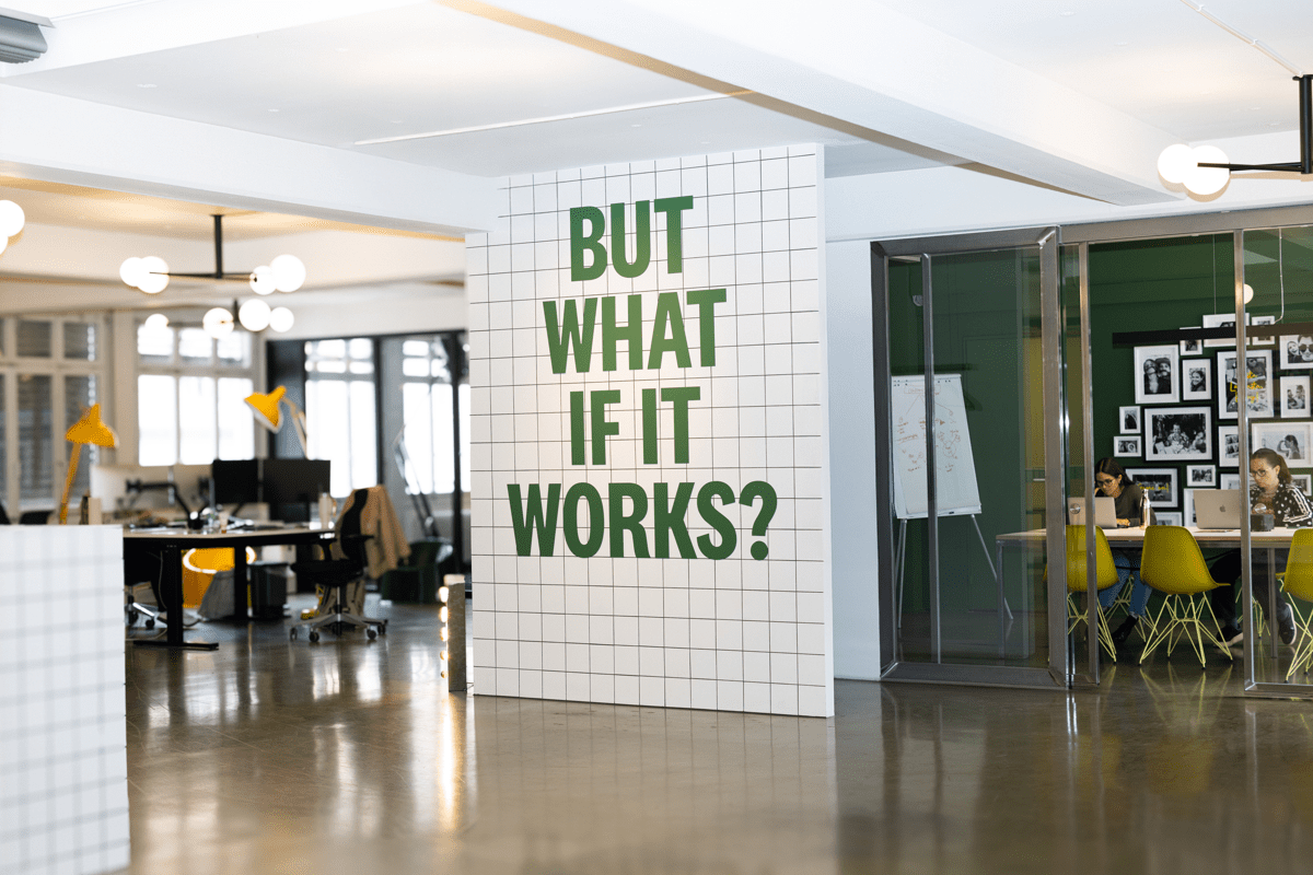 Die Innenräume einer Werbeagentur mit einem grossen Schriftzug «But what if it works?» an einer Wand