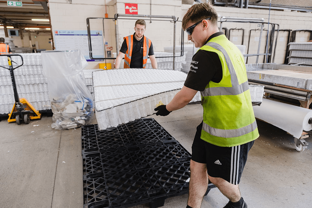 Two men lifting a mattress