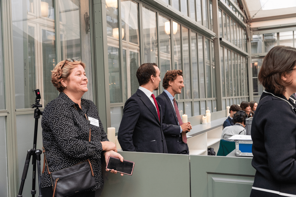 A woman and two men smile at something off the photo