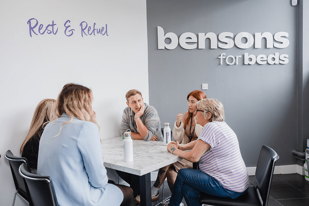 Group of people sat chatting having lunch in a staff canteen