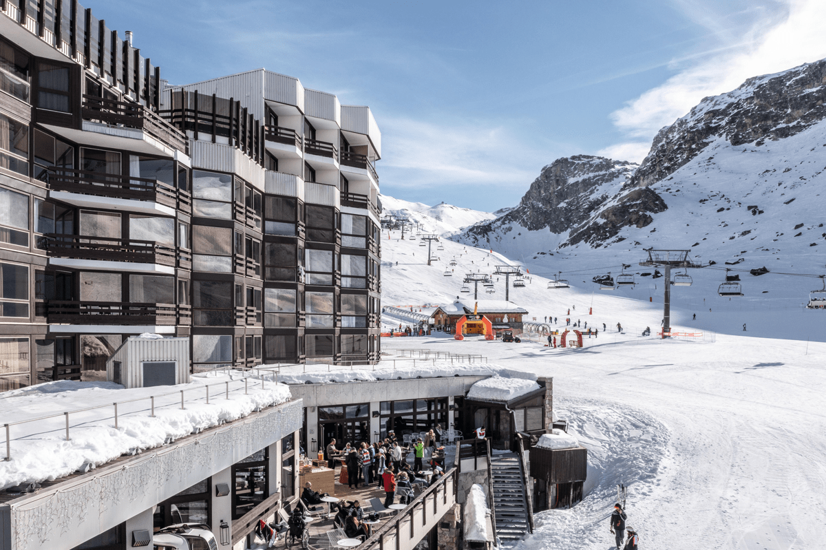 Vue d'un complexe hôtelier à la montagne, entouré de neige.