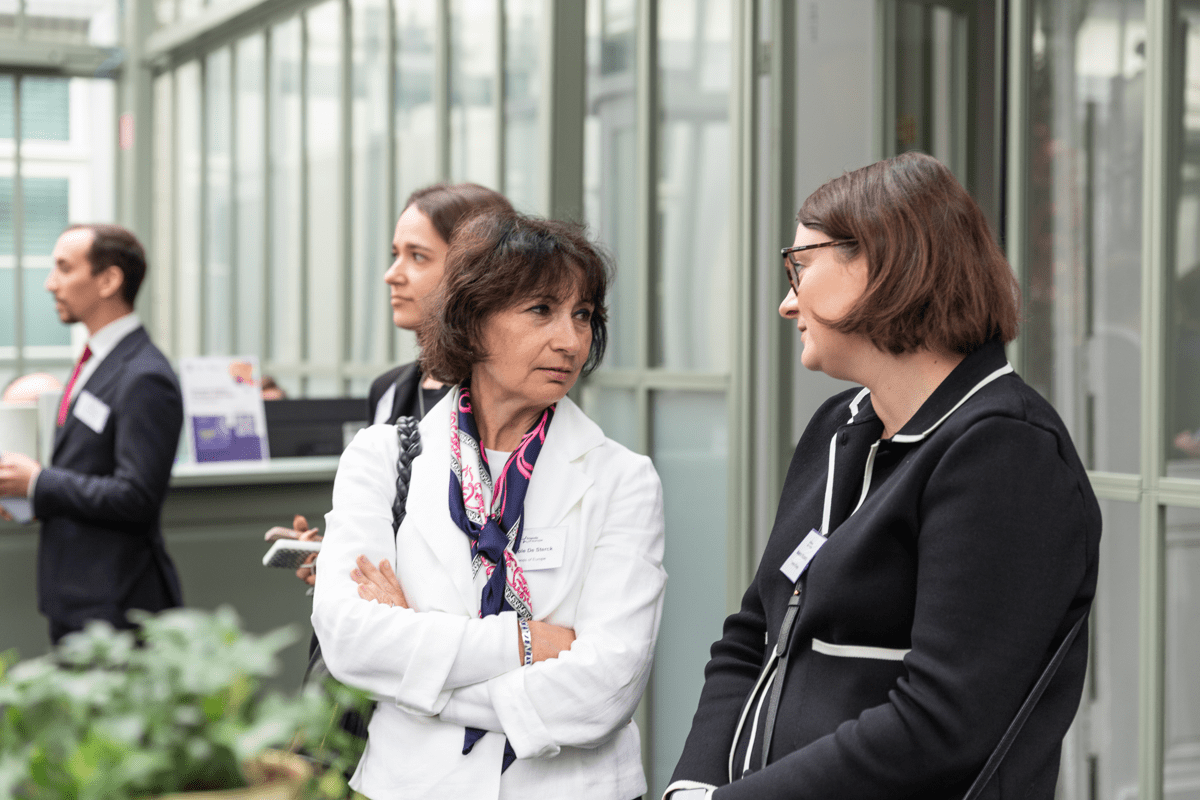 Two women stand together talking