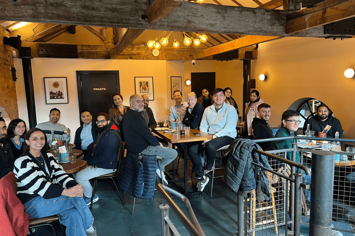 A team of people sat around tables smiling at the camera