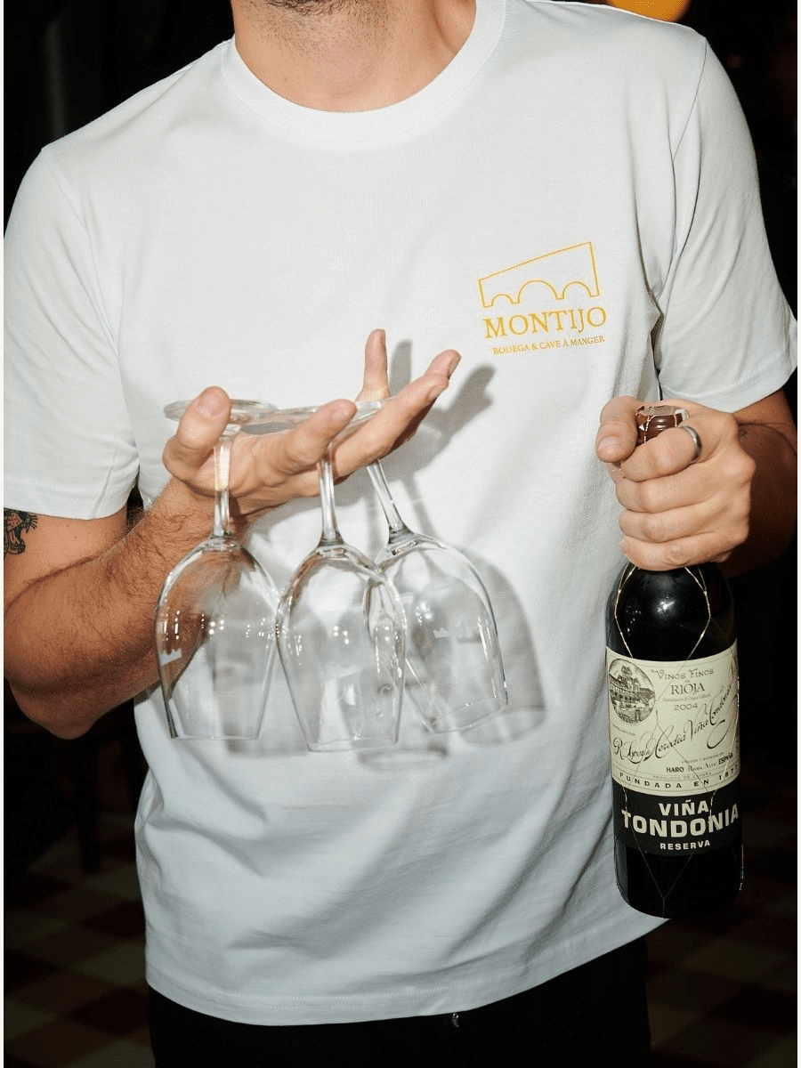 Serveur du Montijo tenant une bouteille de vin et des verres lors du service en salle