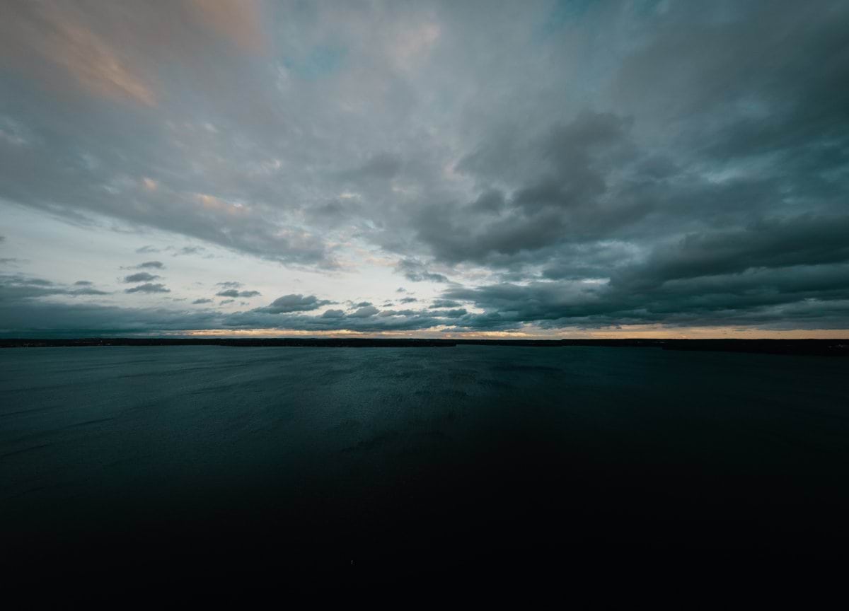 a large body of water under a cloudy sky