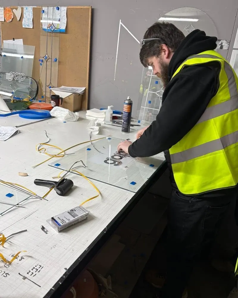 A GAP team member fitting glass in the workshop