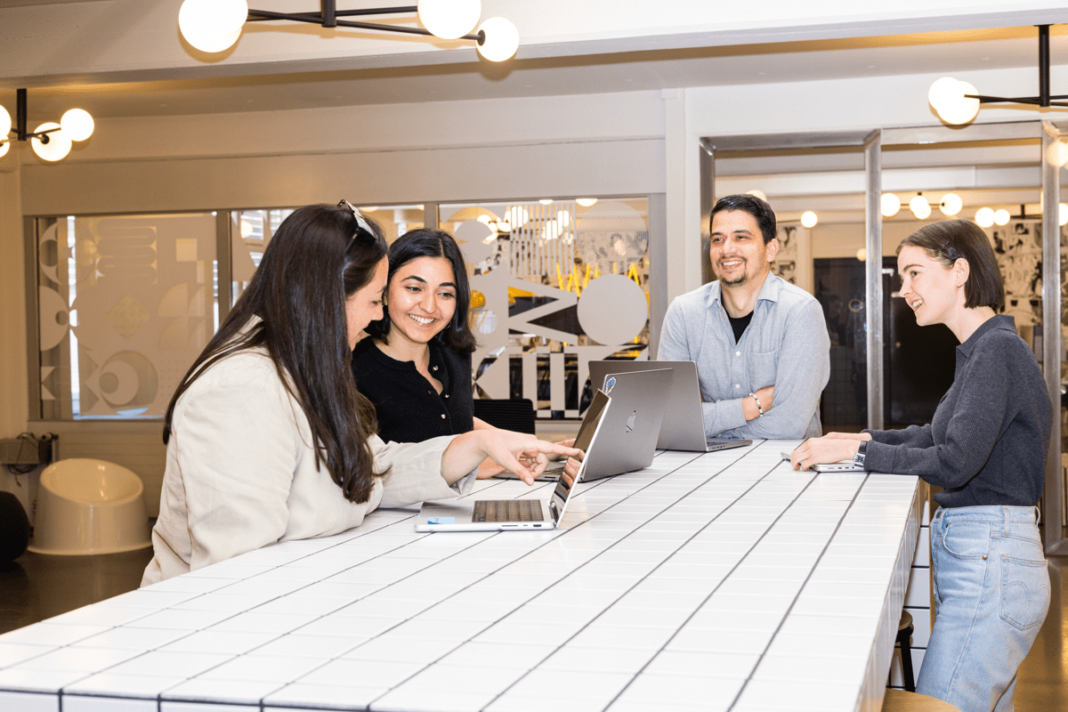 Mitarbeitende einer Werbeagentur an einem Stehtisch in einem Meeting