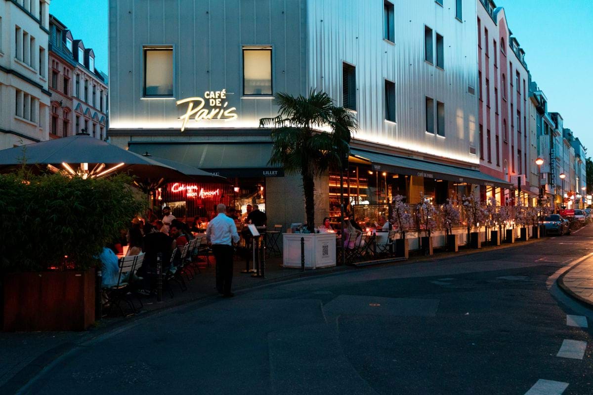 a group of people sitting outside of a restaurant