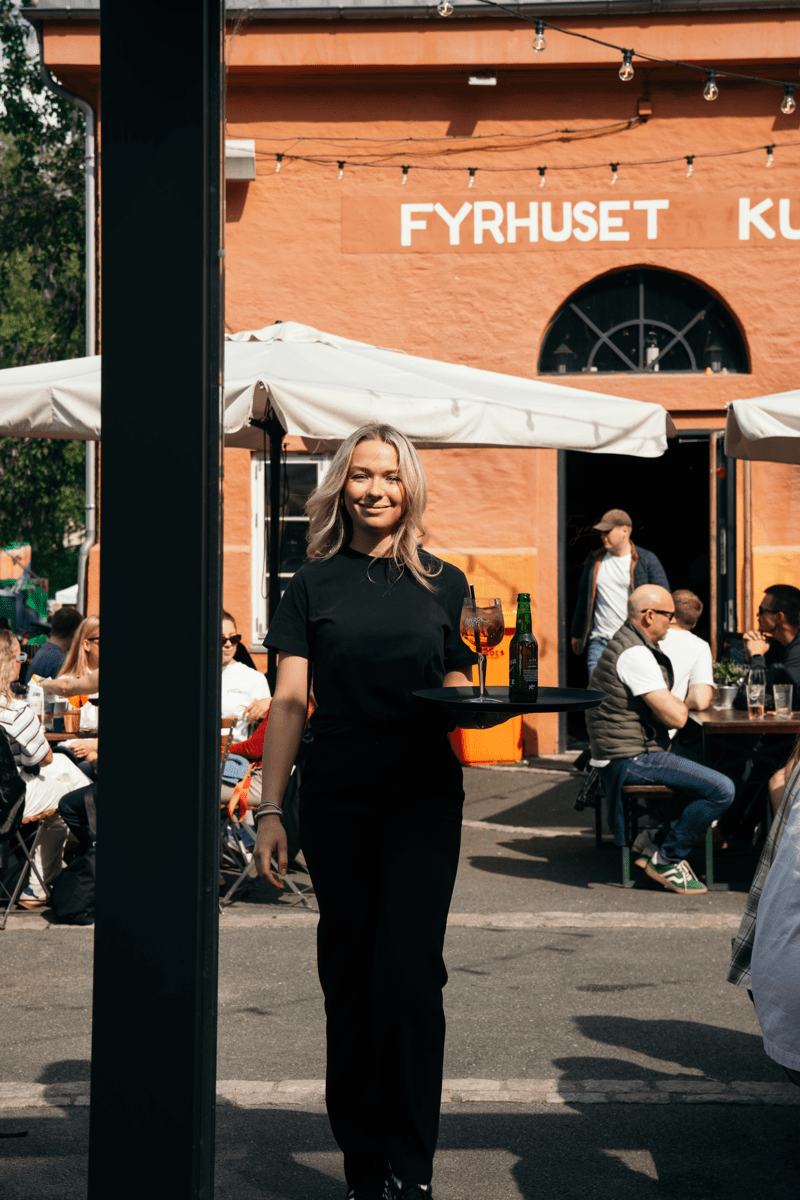 En ansatt smiler utenfor en resturant
