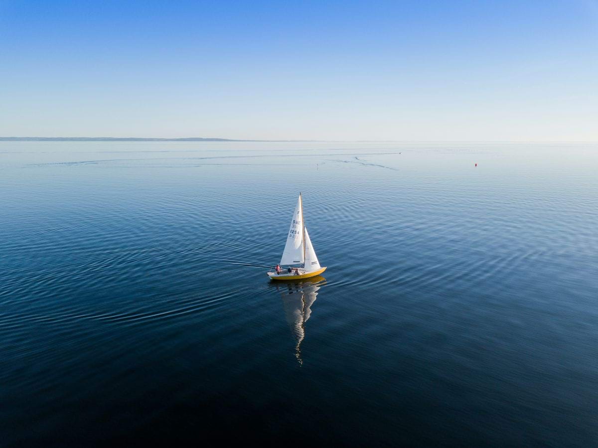 a small sailboat floating on a large body of water