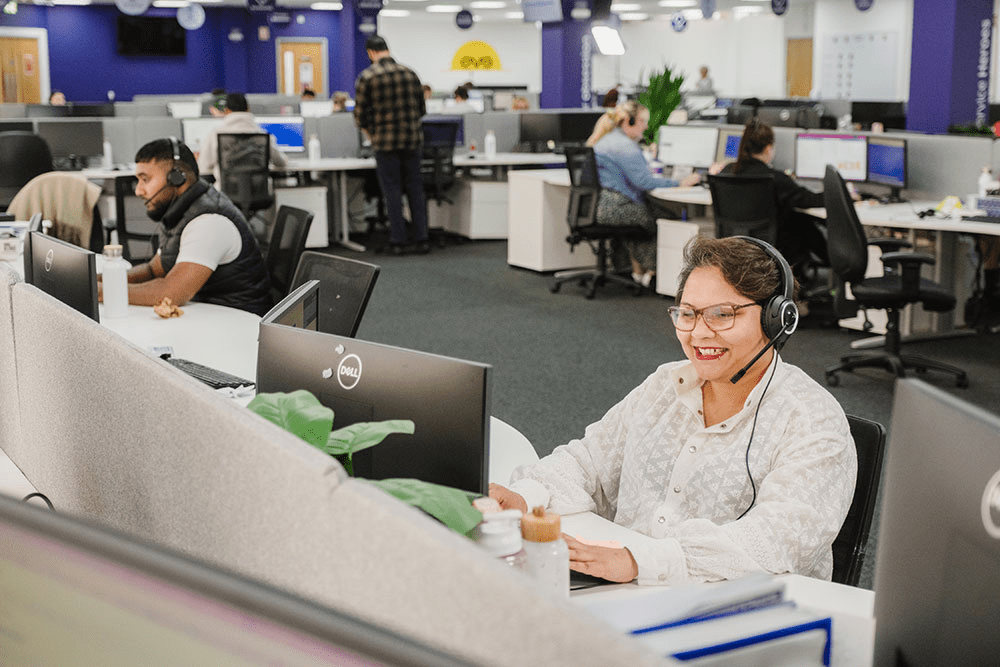 Woman smiling with a headset on in a call centre