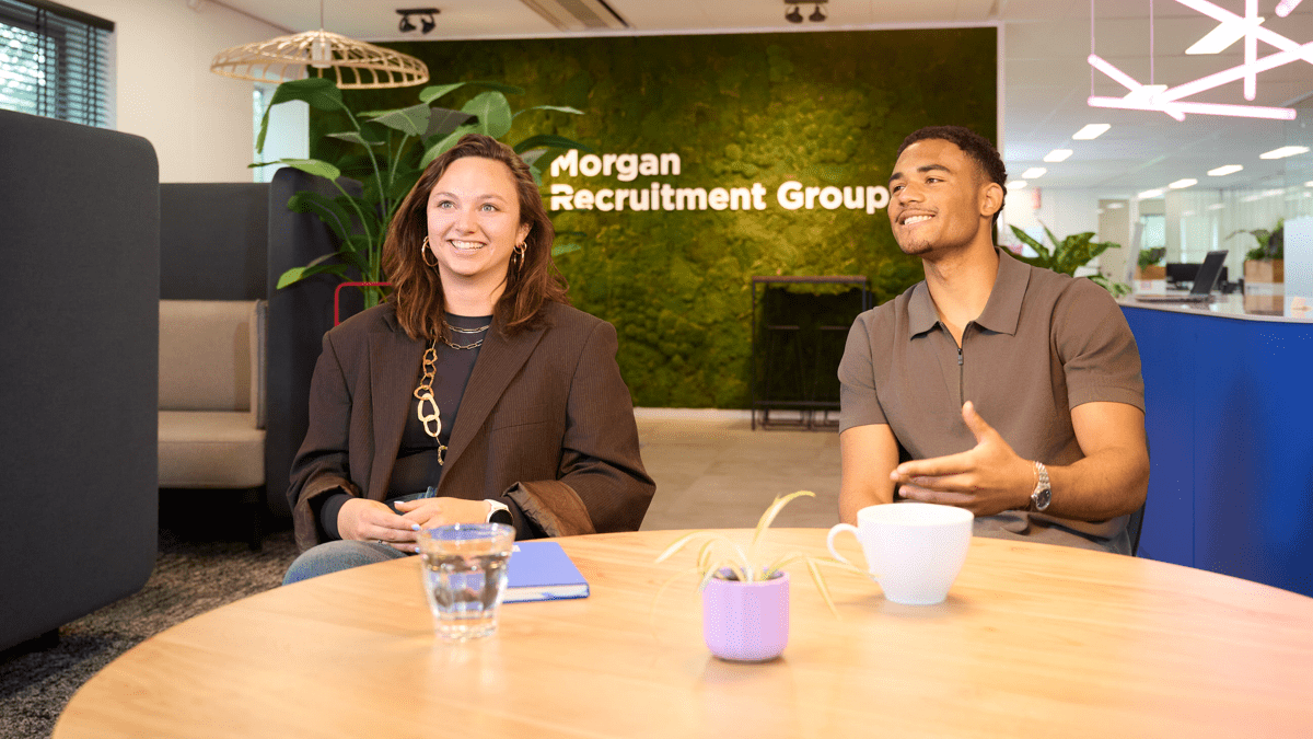 Ontdek de werkomgeving van recruitmentbureau Morgan Recruitment Group in Amsterdam met het team voor de groene moswand en het logo.