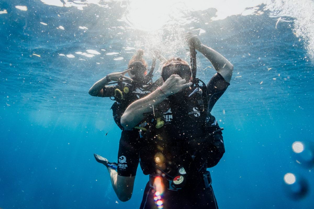 man in black wetsuit diving on water