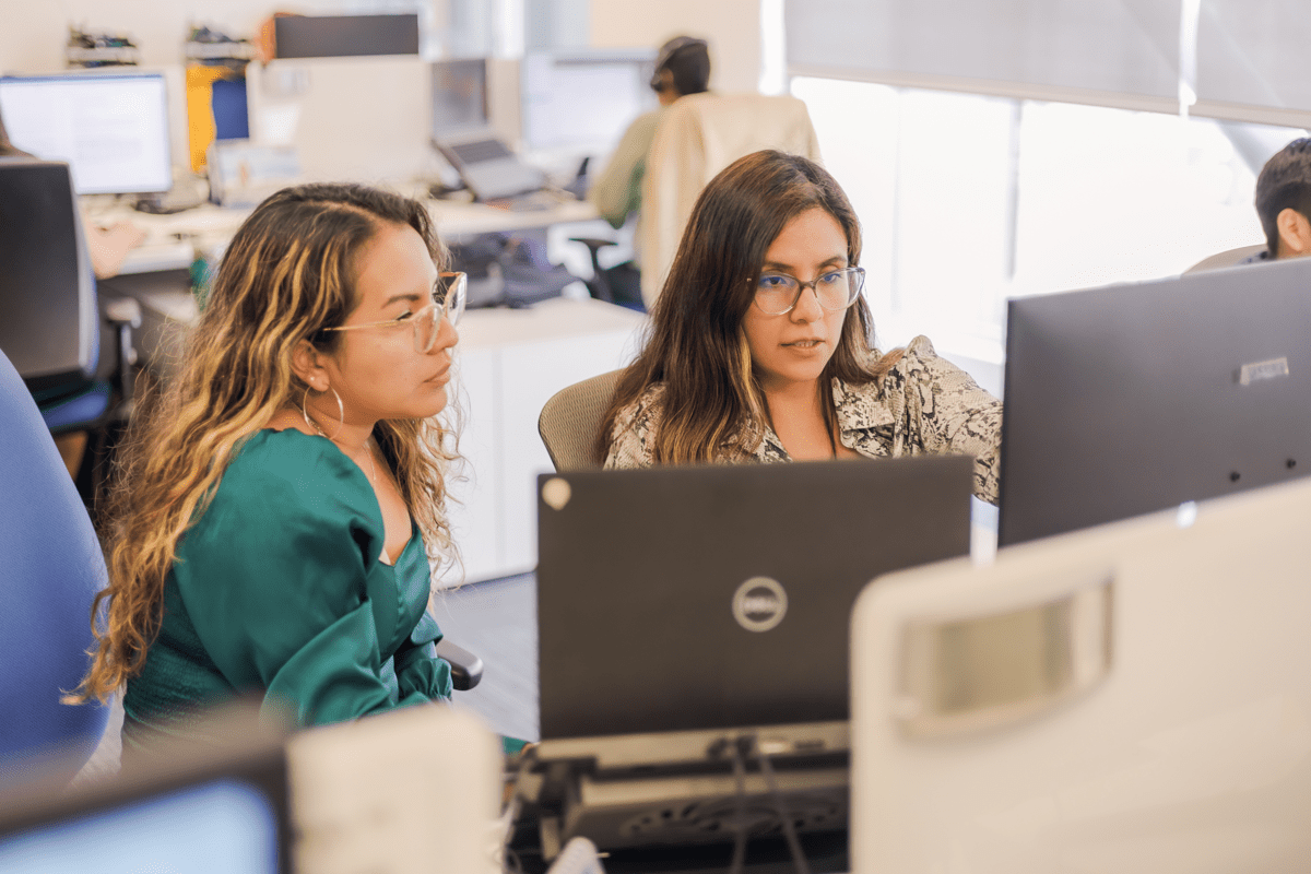 Two team members working together at a desk in KCB's Lima office