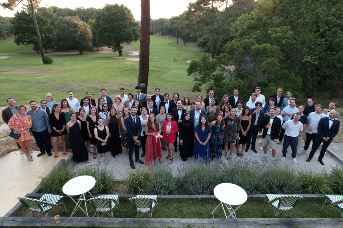 L'équipe Synapse Medicine réunie en tenue de soirée sur une terrasse, devant un parcours de golf