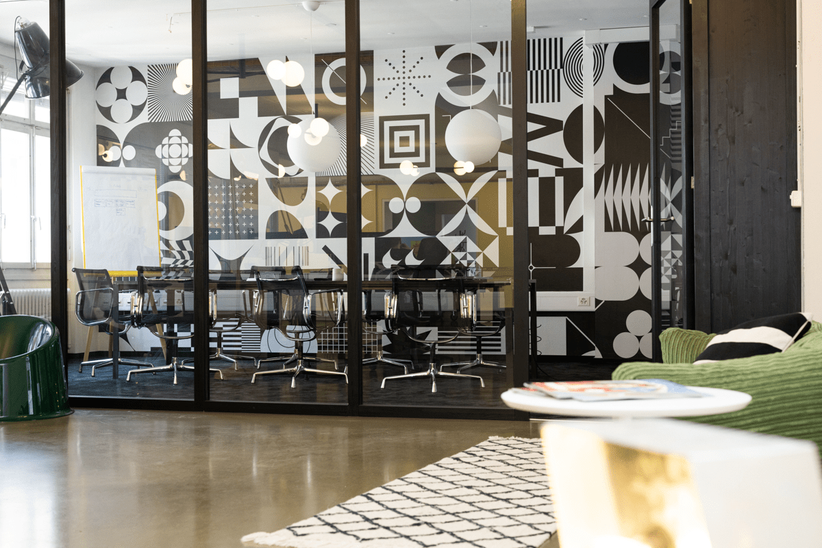 Ein Meetingraum mit Glasfront und schwarz-weisser Wand in einer Werbeagentur