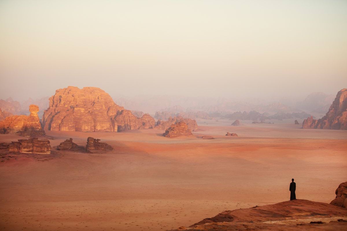 a lone person standing in the middle of a desert