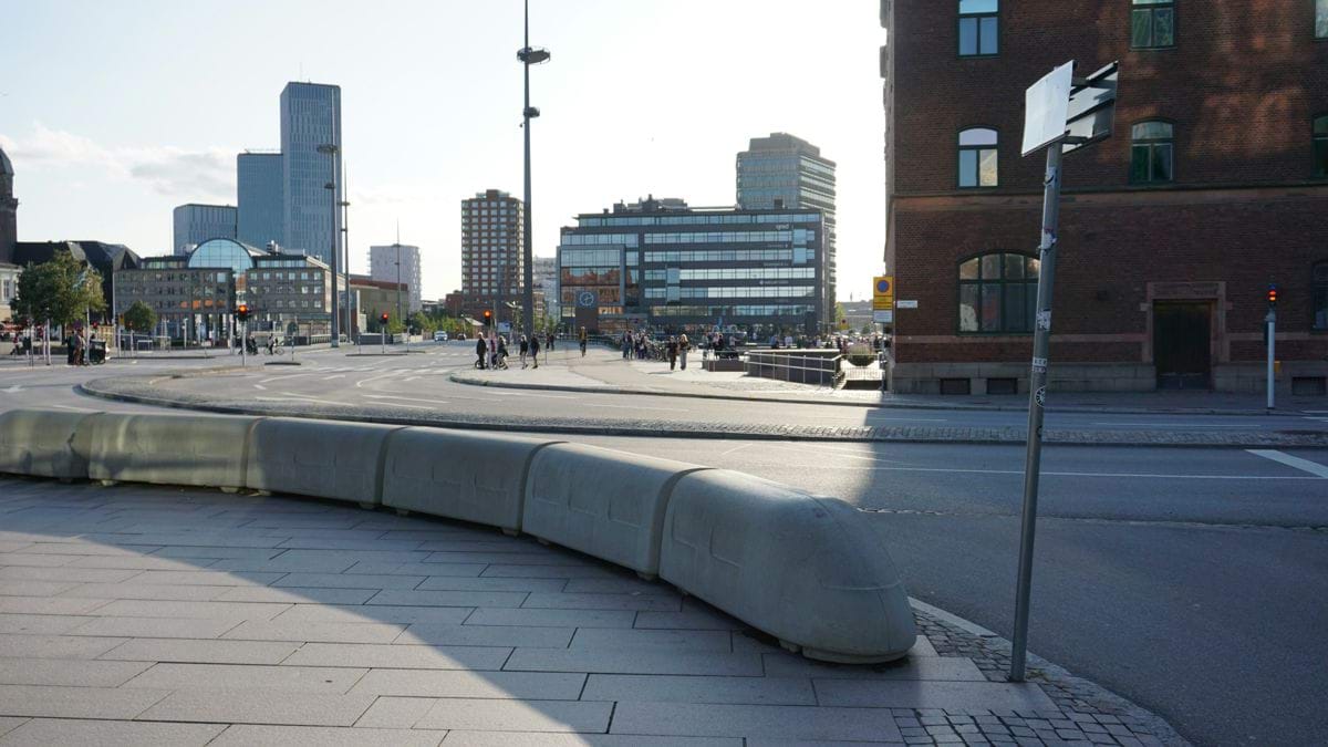 a curved bench sitting on the side of a road