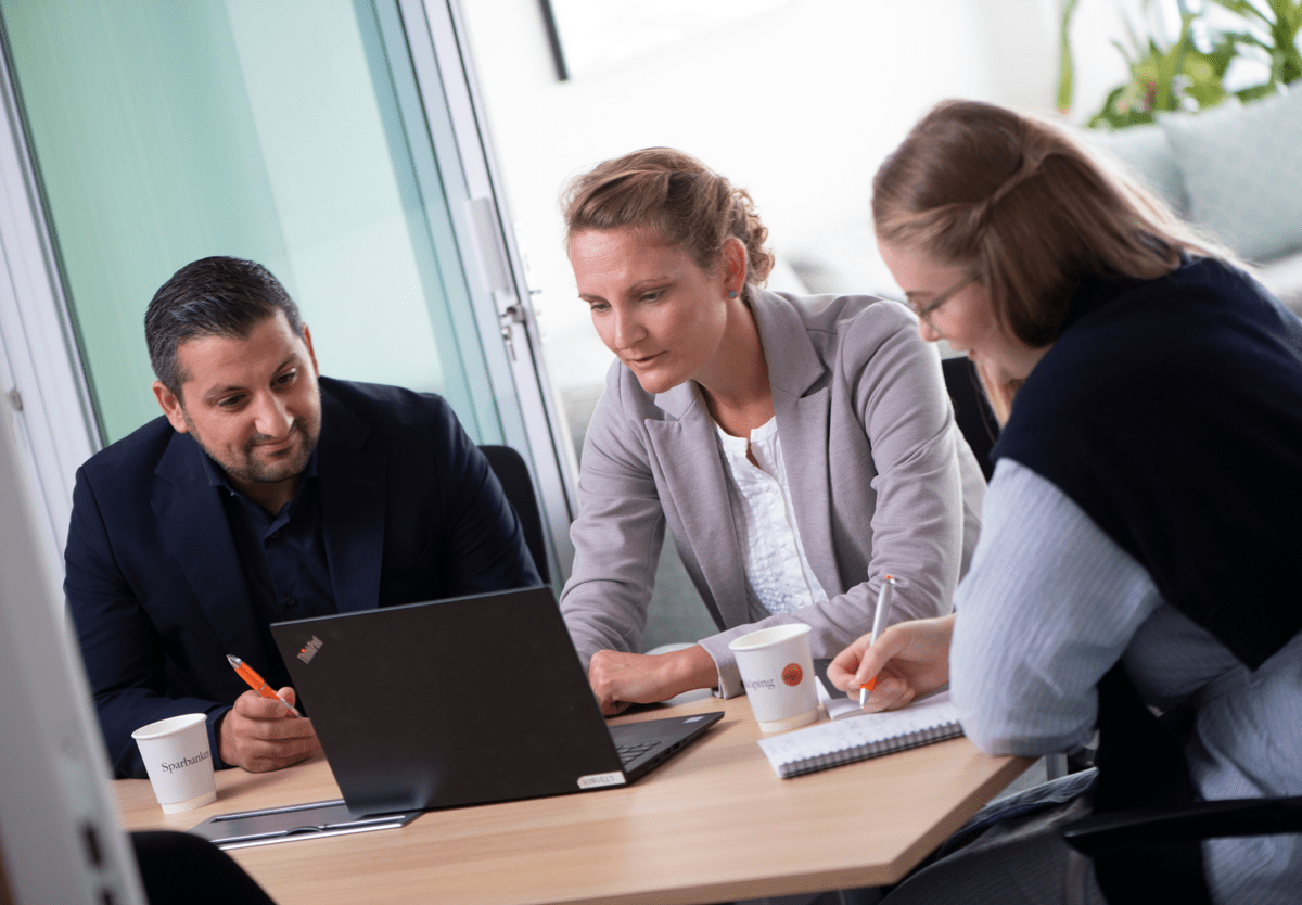 Tre personer tittar mot en datorskärm