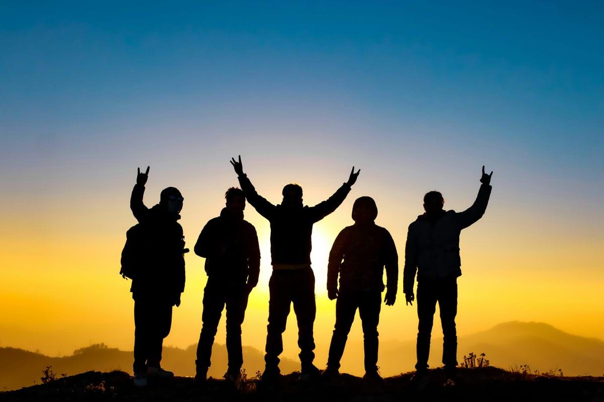 silhouette of people raising their hands