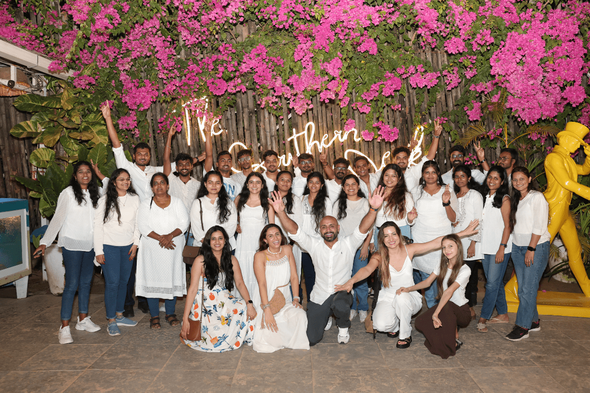 Team smiling for photo wearing white