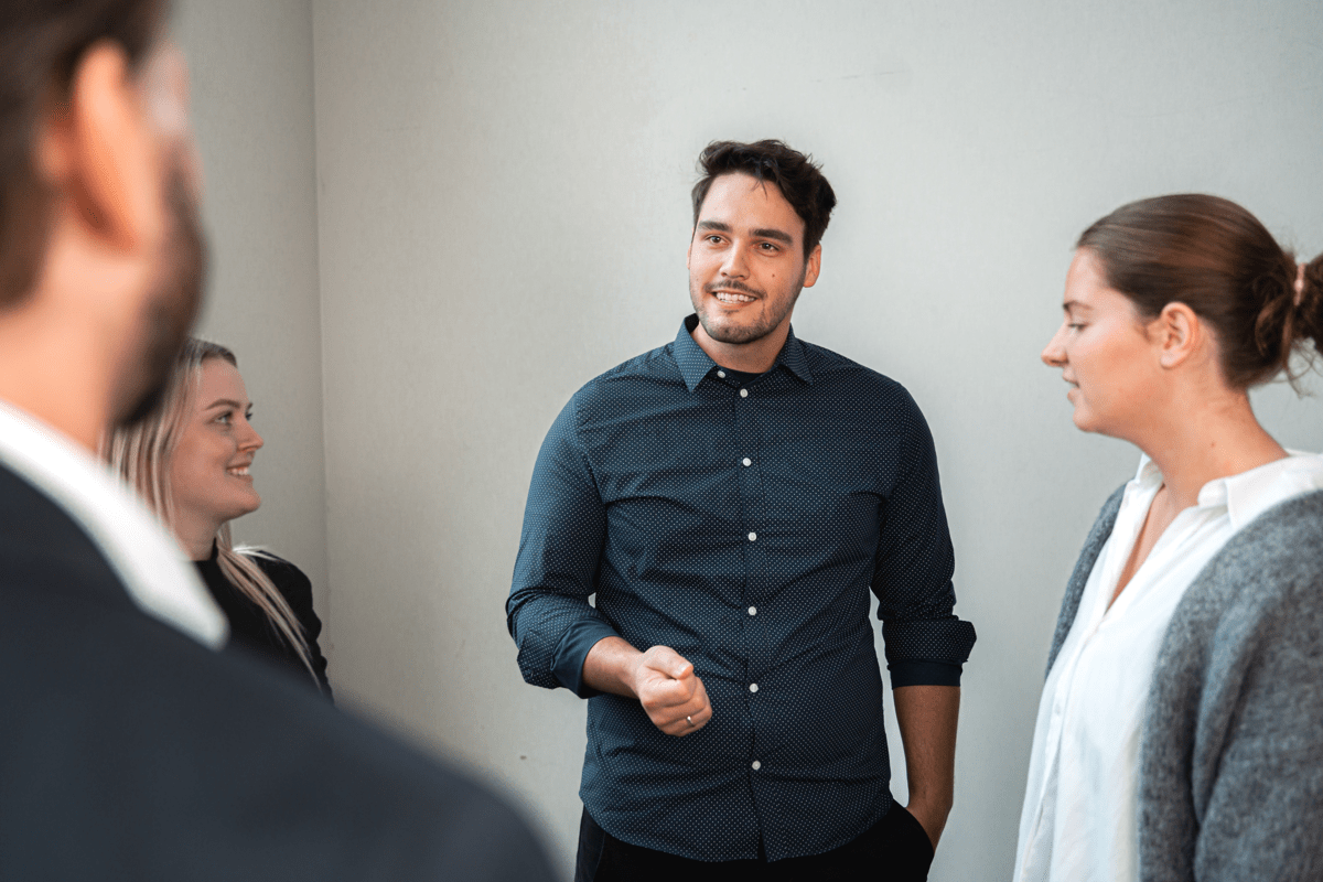 Konsulentteamet fra Excito i samtale med hverandre. Smil og god stemning. Seniorkonsulent Kristian i senter av bildet. 