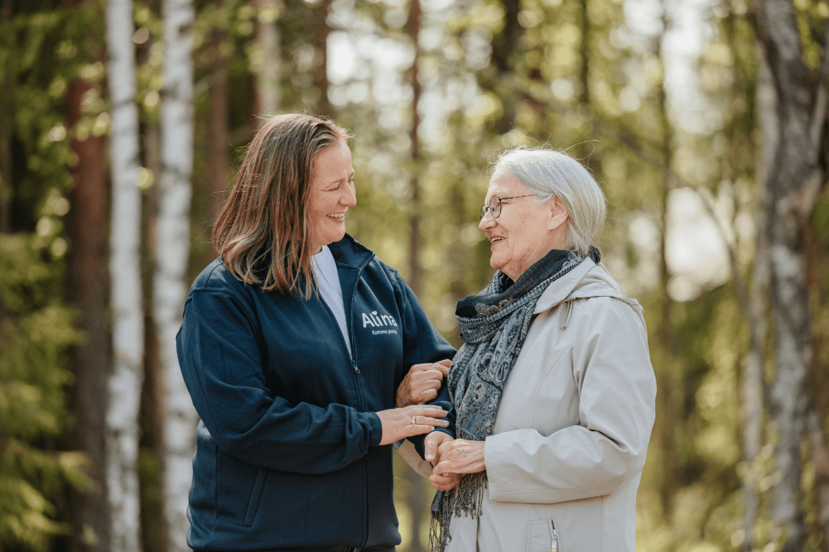 Mummo ja hoitaja ovat kävelyllä ulkona