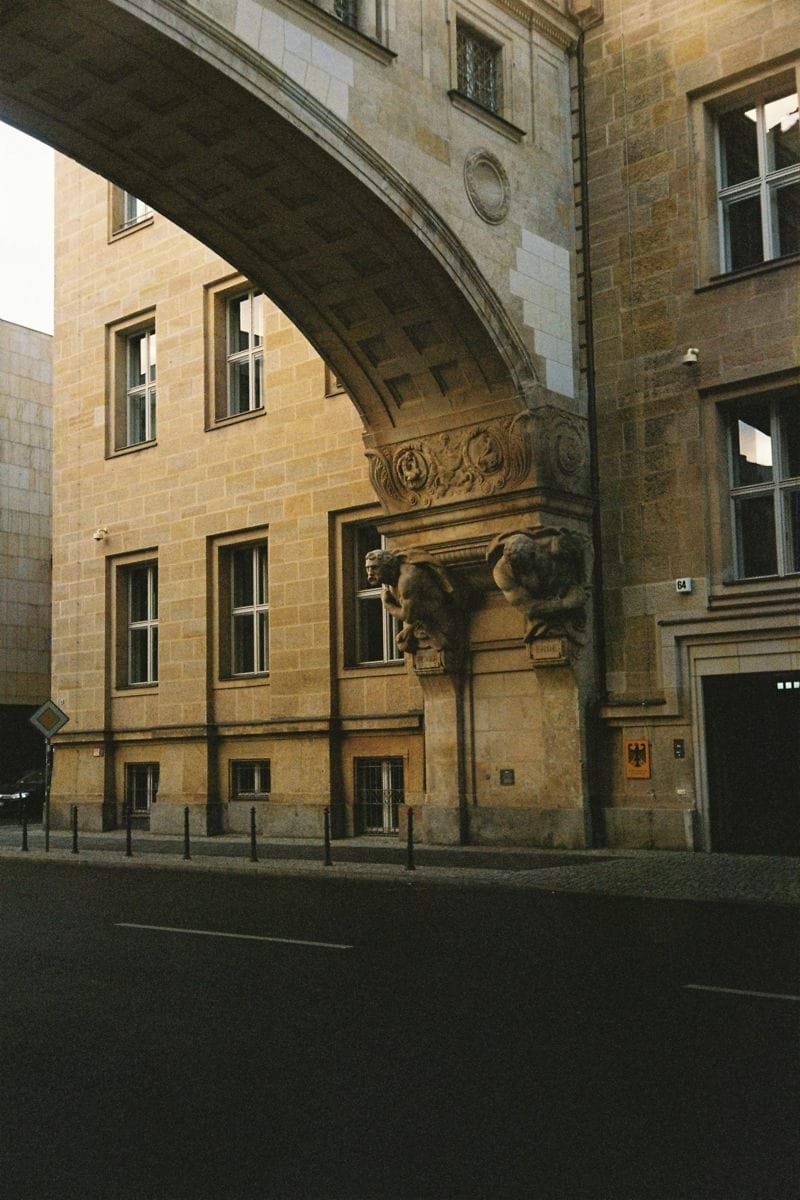 An arched stone building facade with windows.