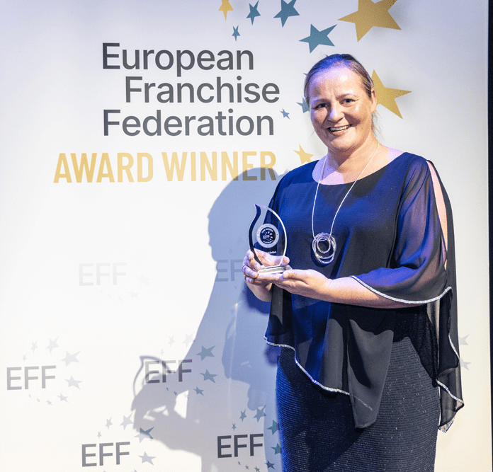 Sari Körkkö Euroopan paras franchisingyrittäjä -pokaalin kanssa
