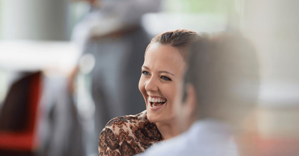 Lachende vrouw die in gesprek is