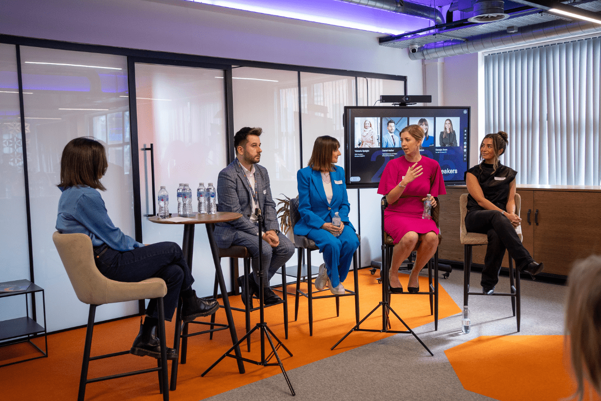 Someone leading a four person panel where one is talking expressively