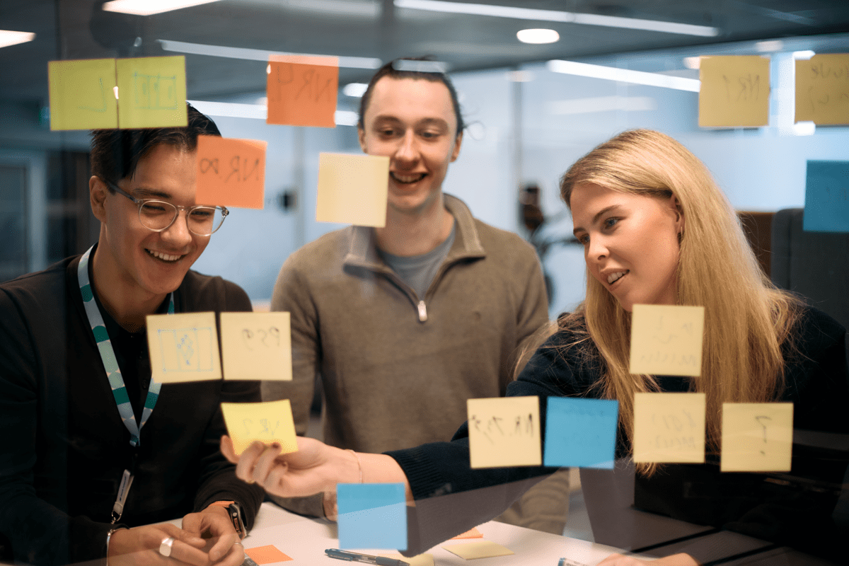 Ansatte hos Norsk helsenett i en engasjerende workshop med post-it lapper på glassvegg