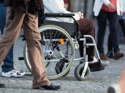 Person in a wheelchair on a cobbled street