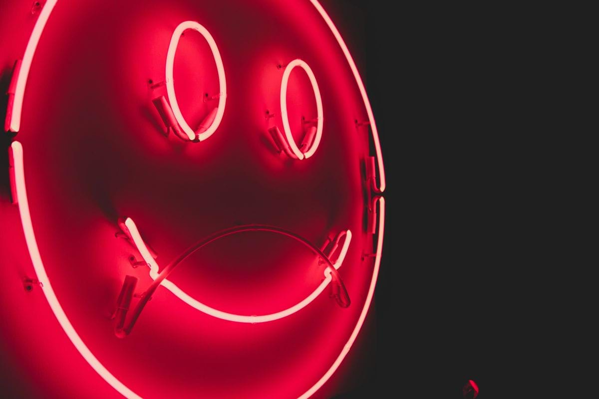 a red neon sign with a smiley face on it