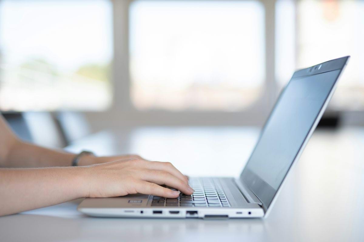 a close up of a person typing on a laptop