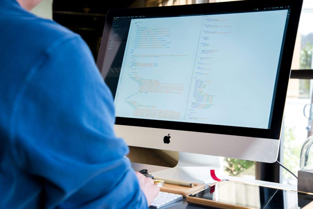 person facing monitor while typing during daytime