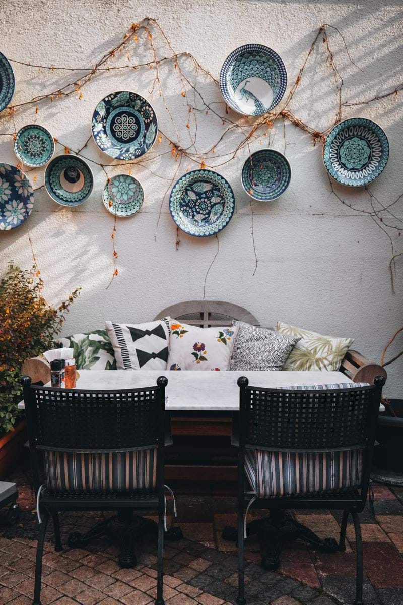 a table with chairs and plates hanging on the wall