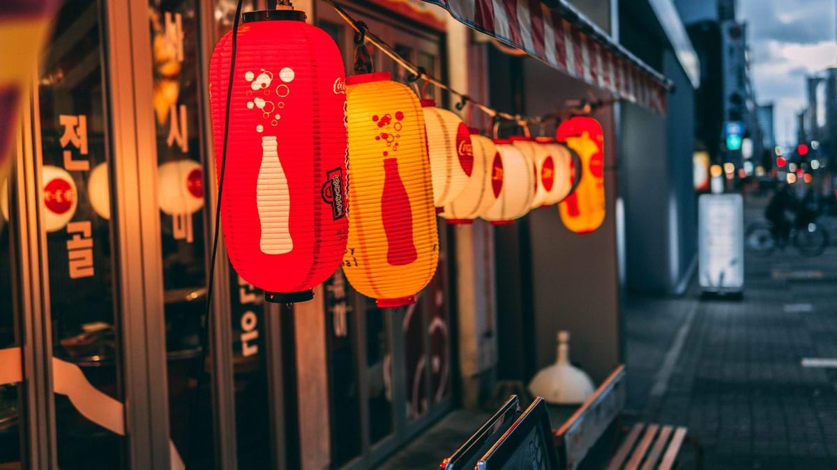 a row of red and yellow lanterns hanging from a building