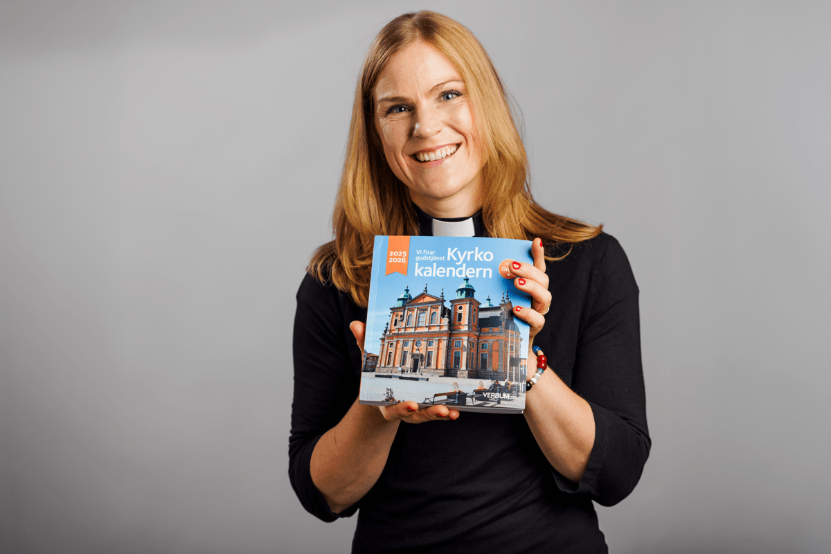 Förläggaren håller upp Kyrkokalendern