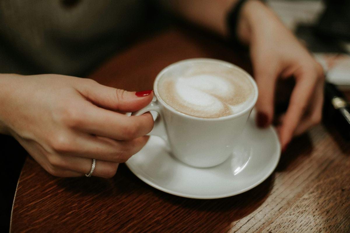 person holding white ceramic mug with coffee