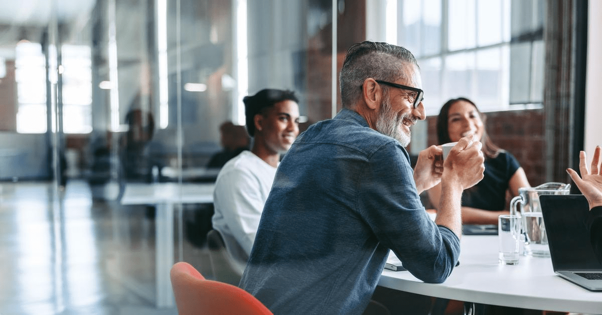 happy-mature-businessman-attending-meeting-with-team.jpg