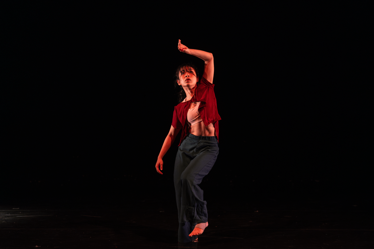 Dancer on stage striking a pose against a black backdrop