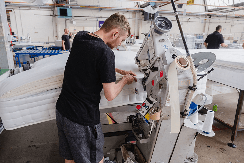 Man working on a machine on a mattress