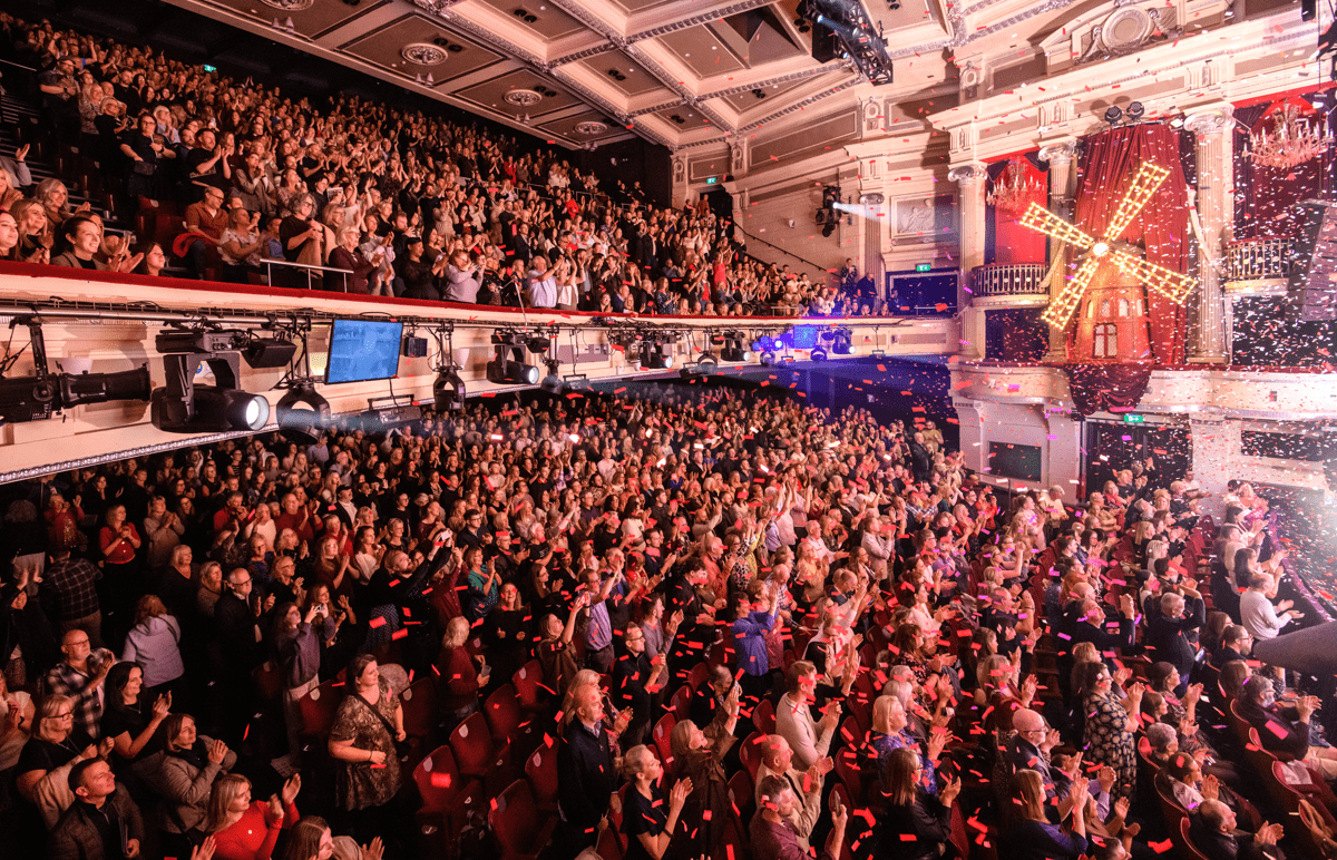 View of auditorium filled with excited audience members. 