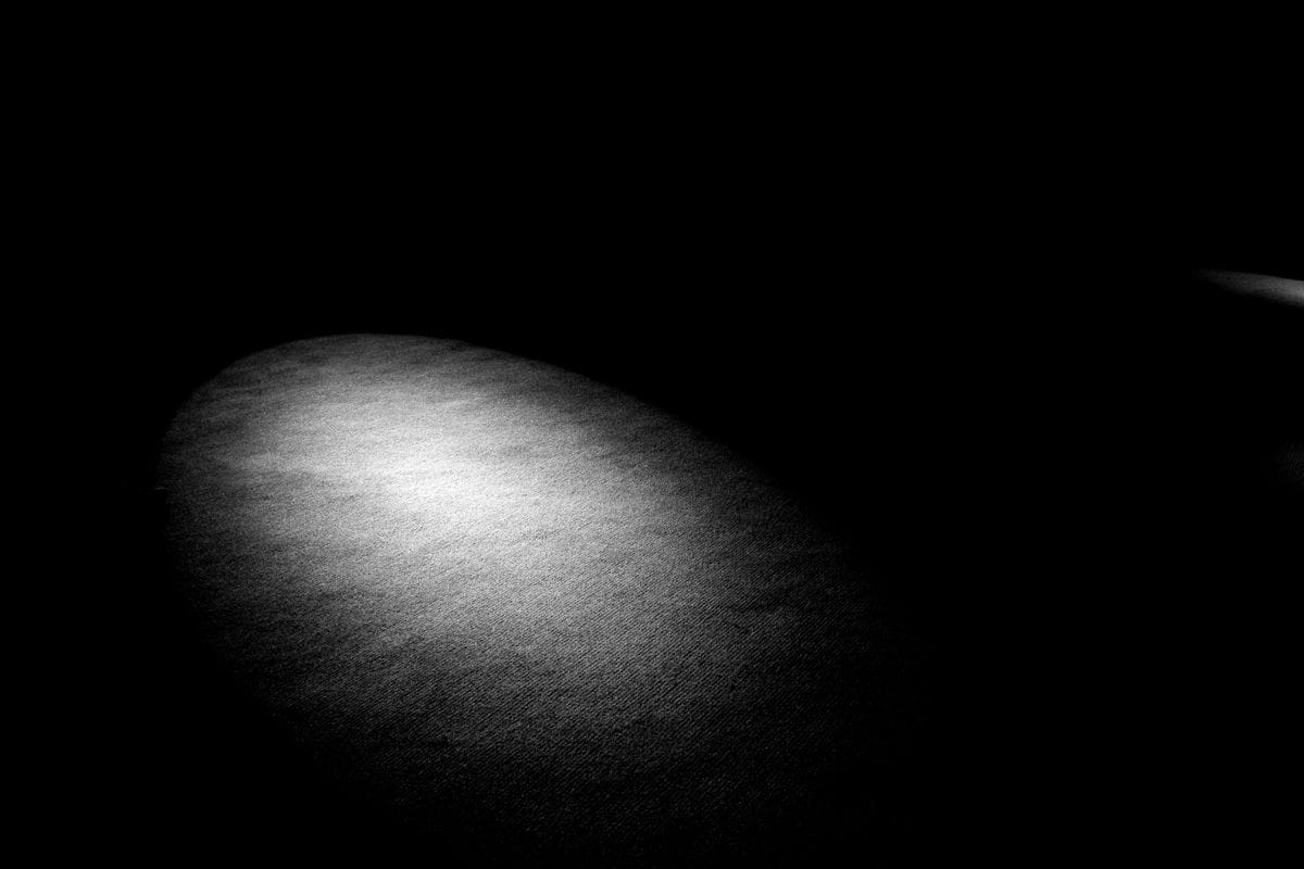 a black and white photo of a light in the dark